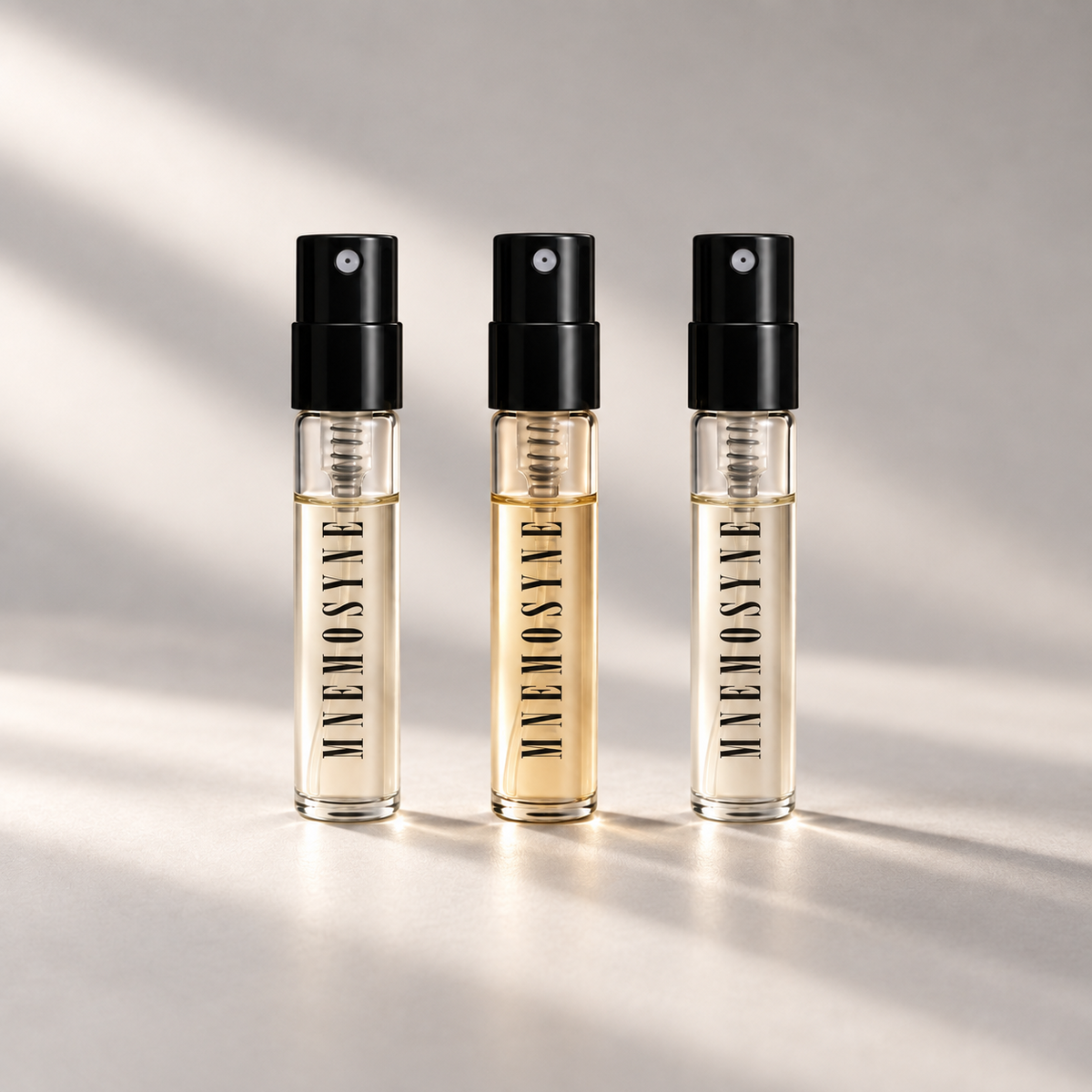 Three MNĒMOSYNE 2 mL perfume spray vials from the Identity Trilogy